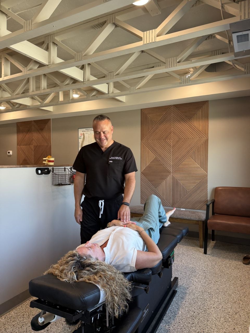 El Dr. Strother evalúa la columna cervical de un paciente en Corrective Chiropractic